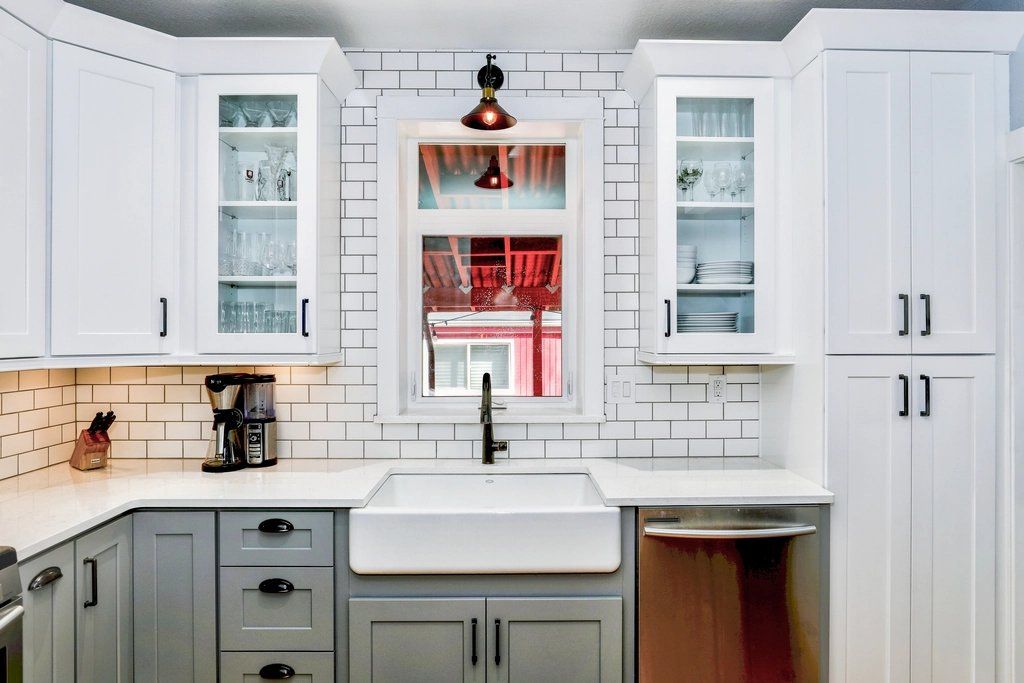 Bright kitchen with white cabinets, subway tile backsplash and farmhouse sink